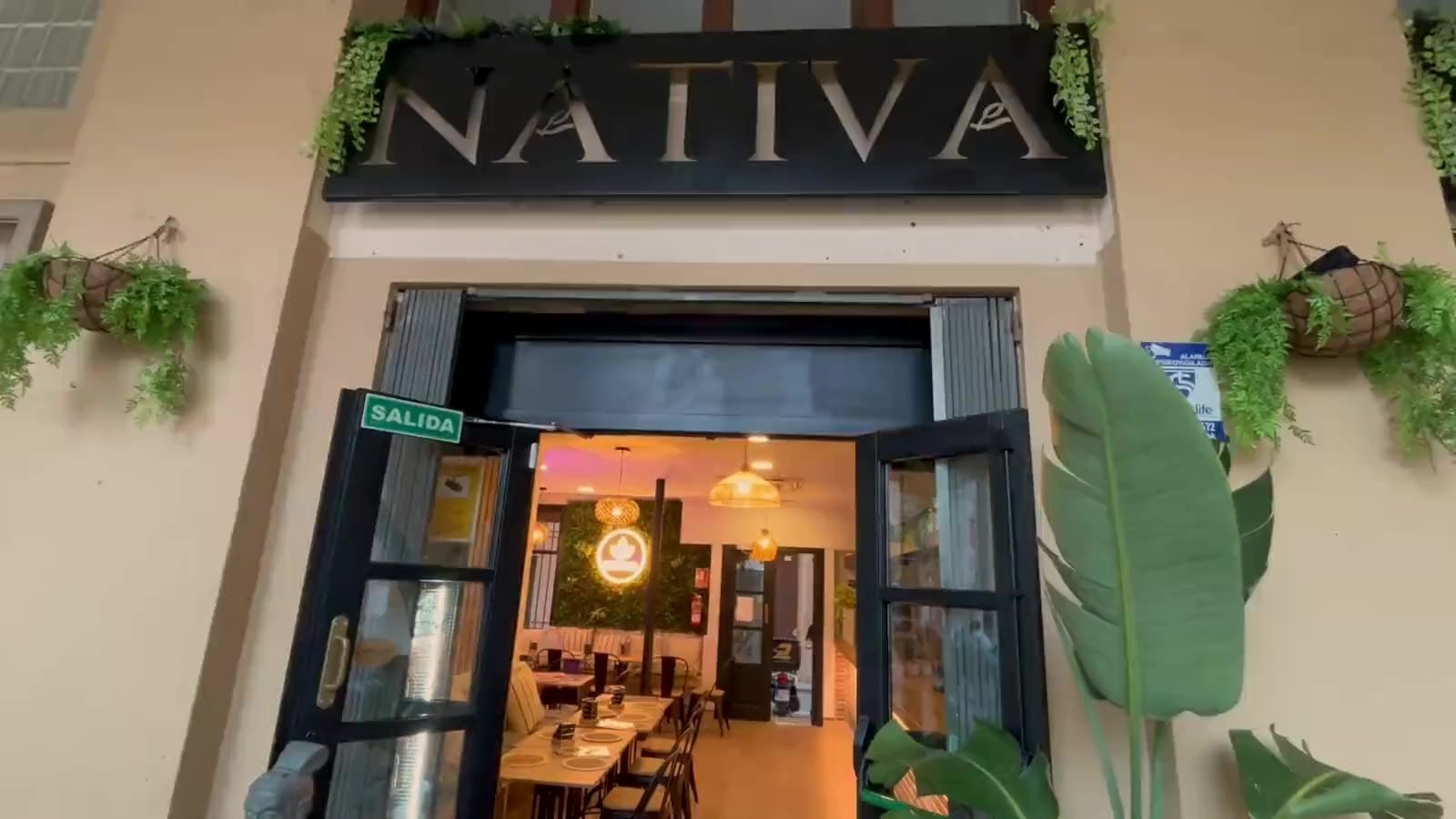 Façana de Nativa a la Plaça de l'Ajuntament, amb el rètol, les portes obertes i la sala il·luminada al fons